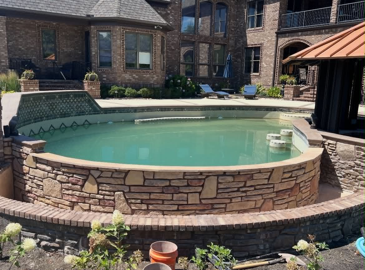 Raised pool wrapped in mixed natural stone veneer