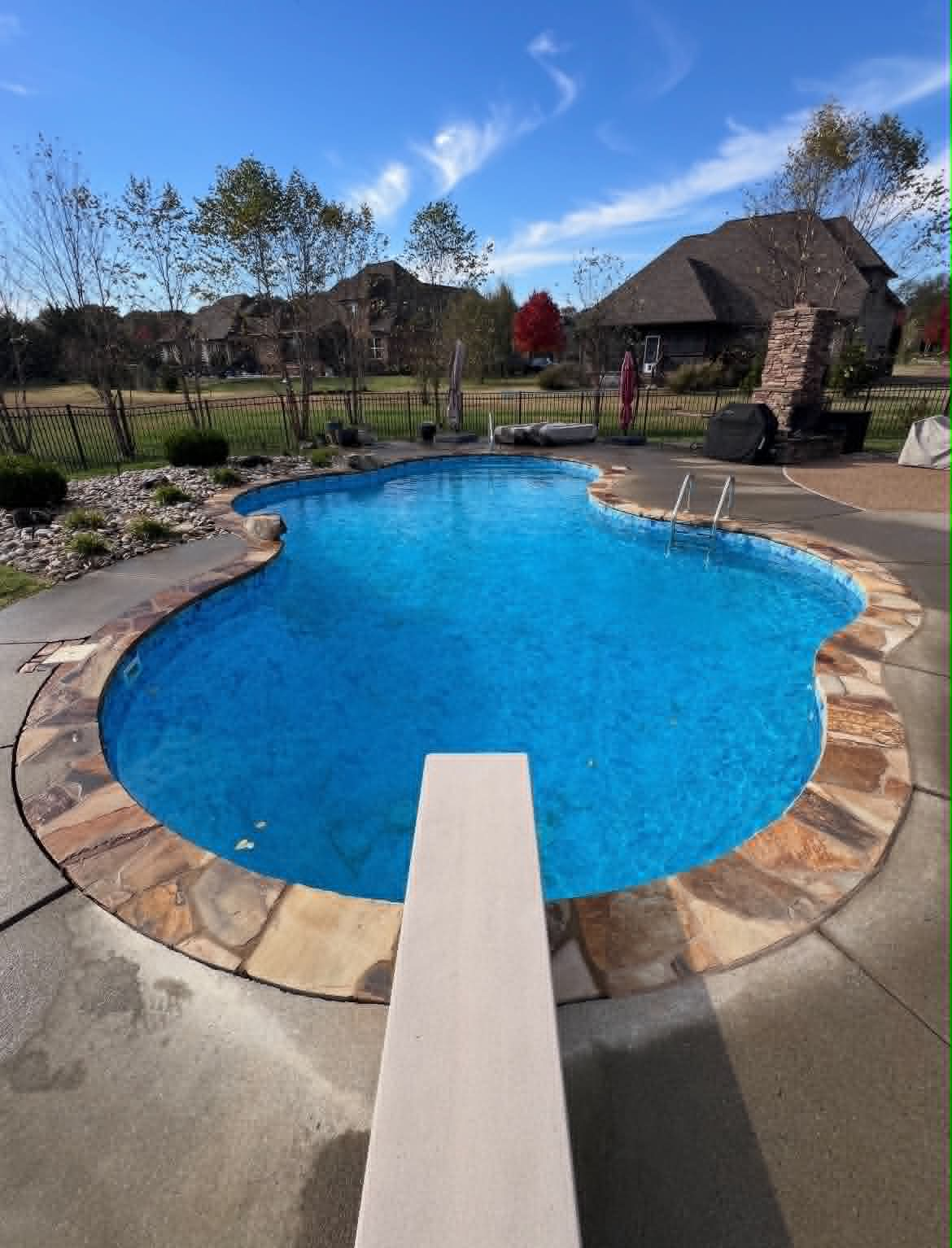 Curved pool with natural stone coping and surrounding deck detail