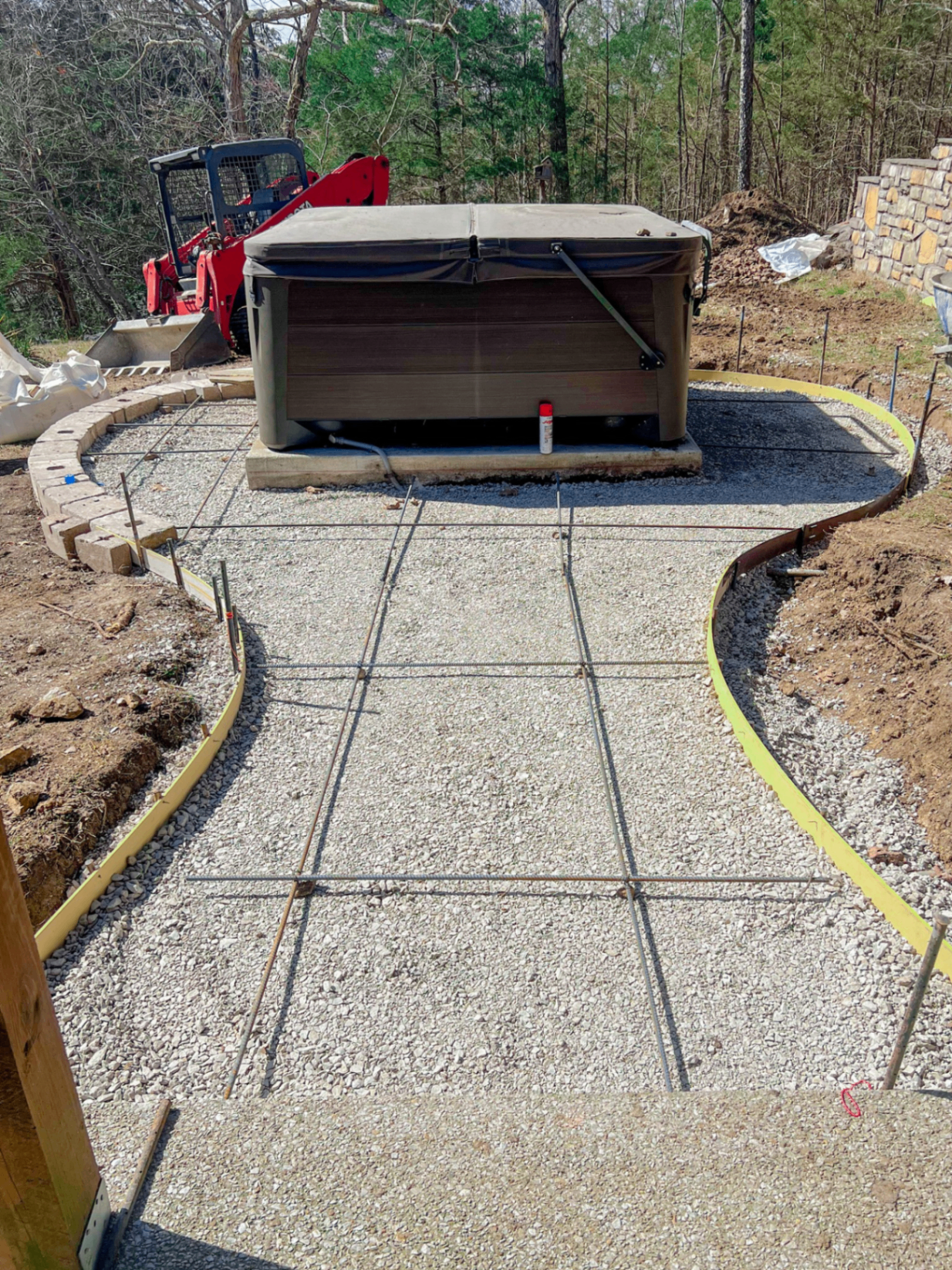 Rebar and gravel base layout prepared for a curved hot tub patio