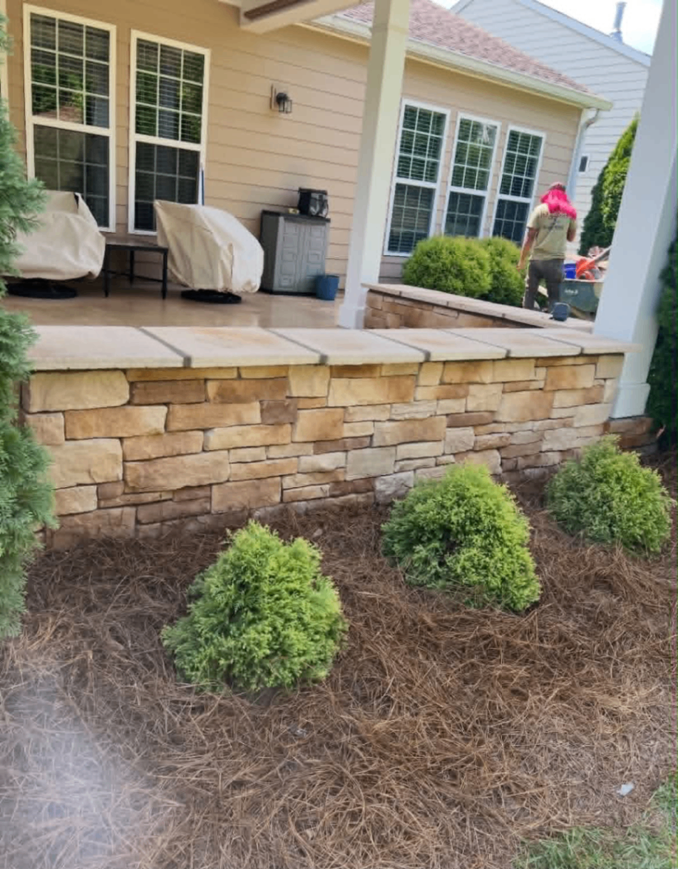 Back porch wrapped with warm-toned stone veneer skirting