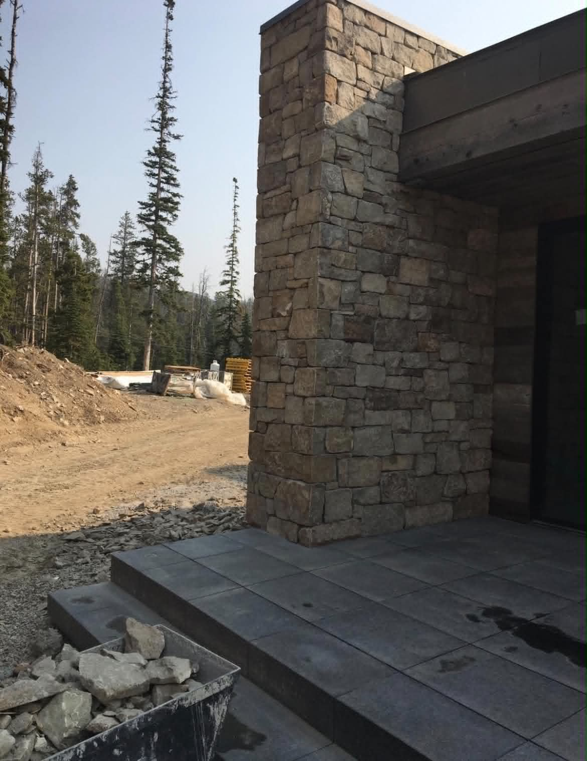 Mountain natural stone column and wall on a custom home exterior