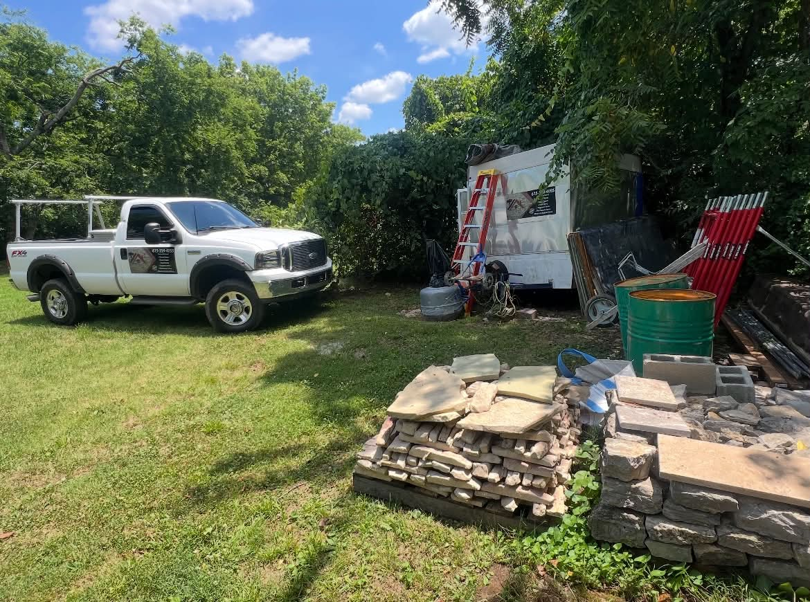 Nunez Masonry work truck and stacked flagstone and cut stone at the shop yard