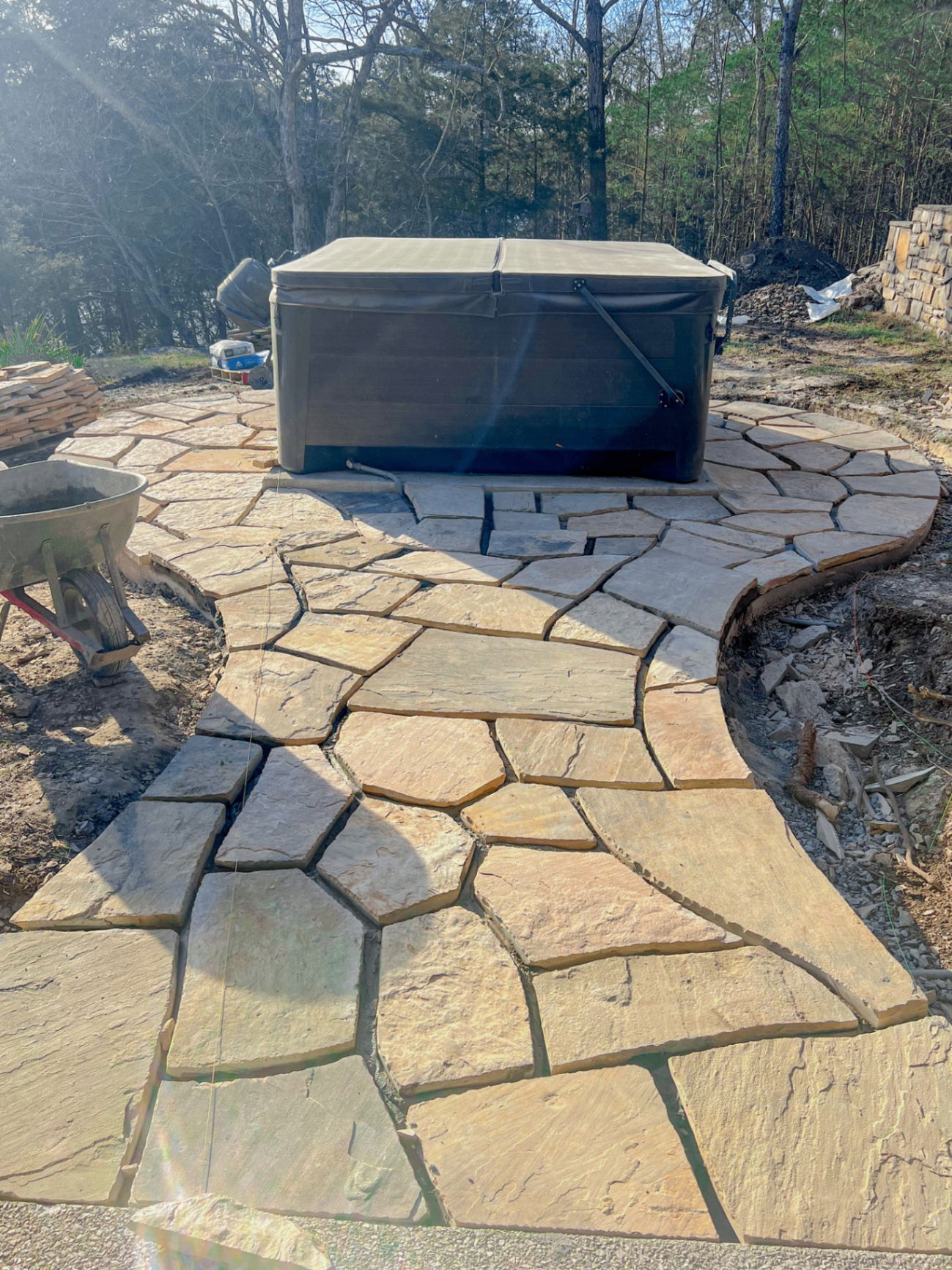Finished natural stone patio and walkway around a hot tub