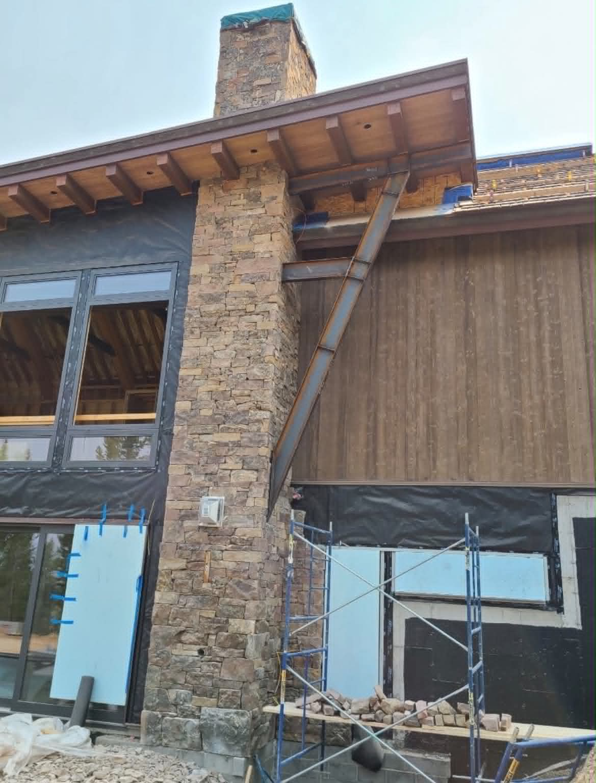Mountain natural stone chimney on a custom timber home exterior