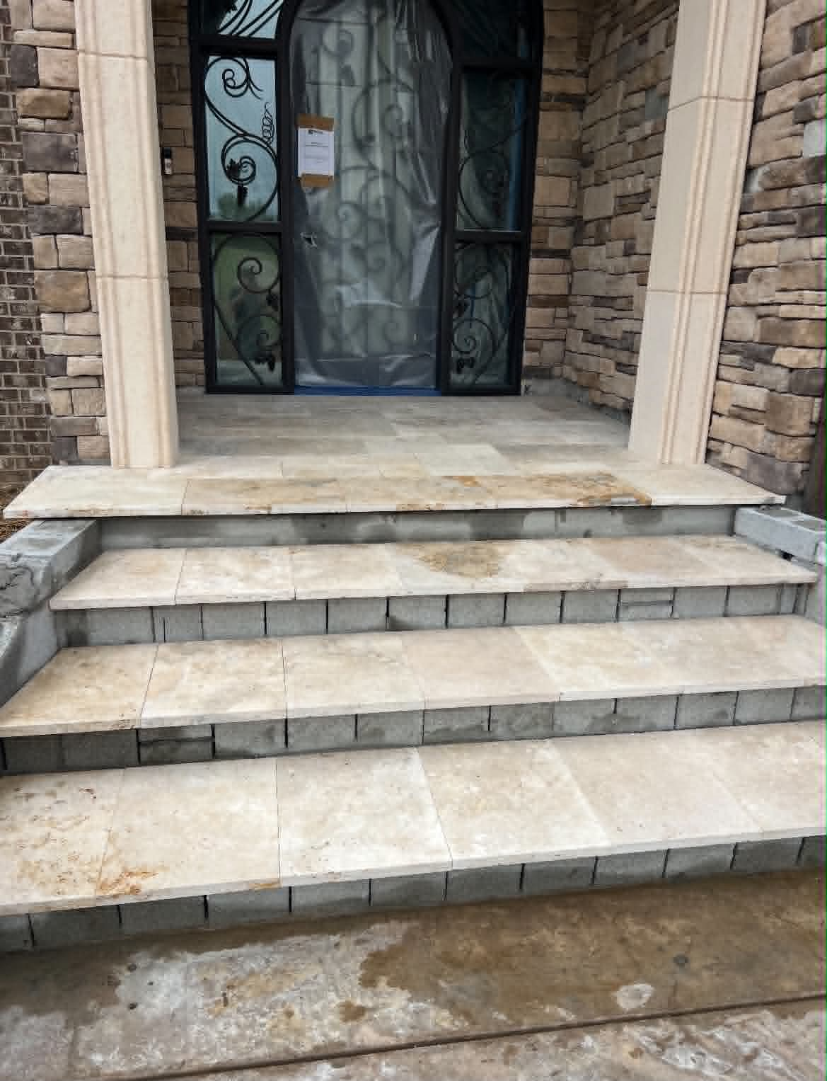 Stone front entry steps with stone veneer surrounding the doorway